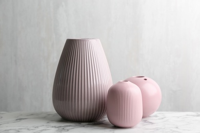 Photo of Stylish empty ceramic vases on white marble table