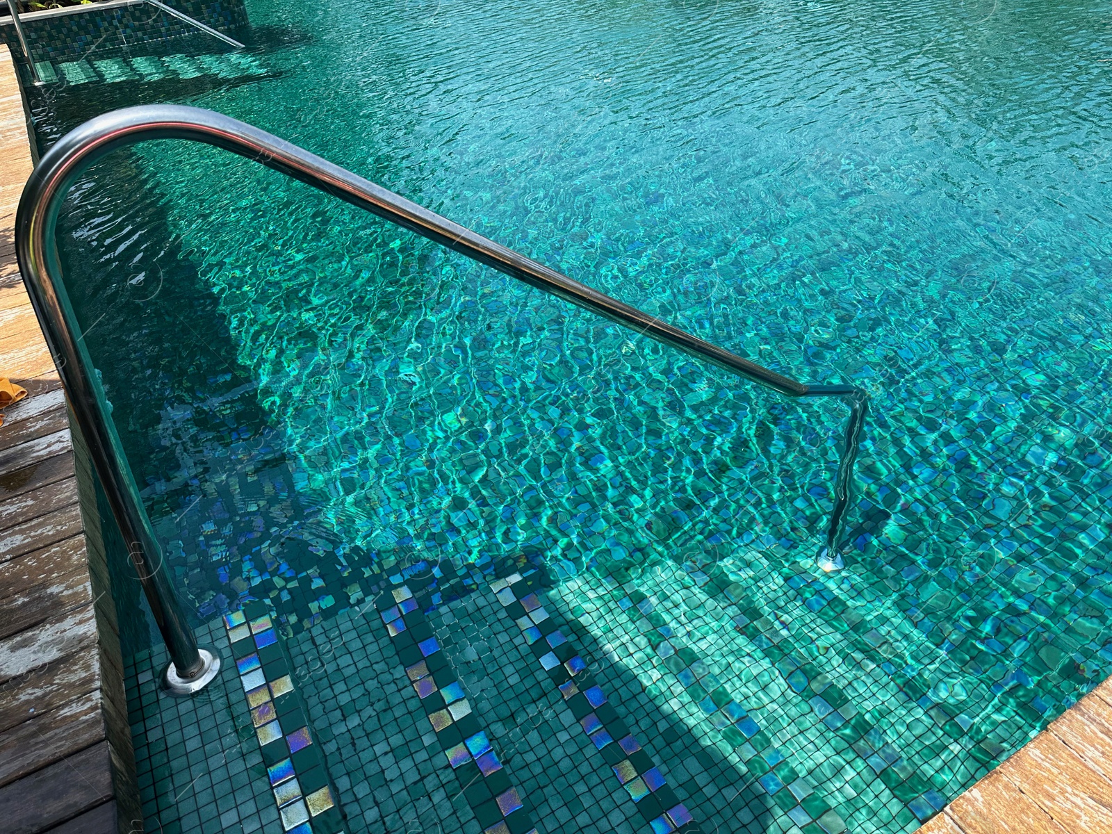 Photo of Metal rail and steps in outdoor swimming pool