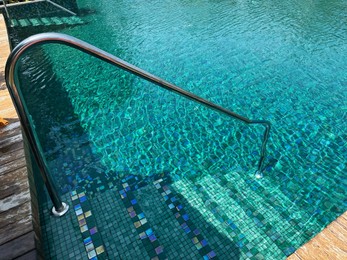 Photo of Metal rail and steps in outdoor swimming pool