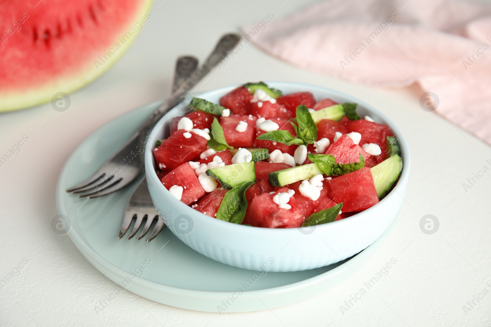 Photo of Delicious salad with watermelon, cucumber and cheese on white table, closeup