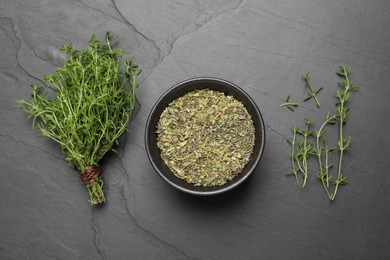 Photo of Bowl with dried thyme and fresh herb on black table, flat lay