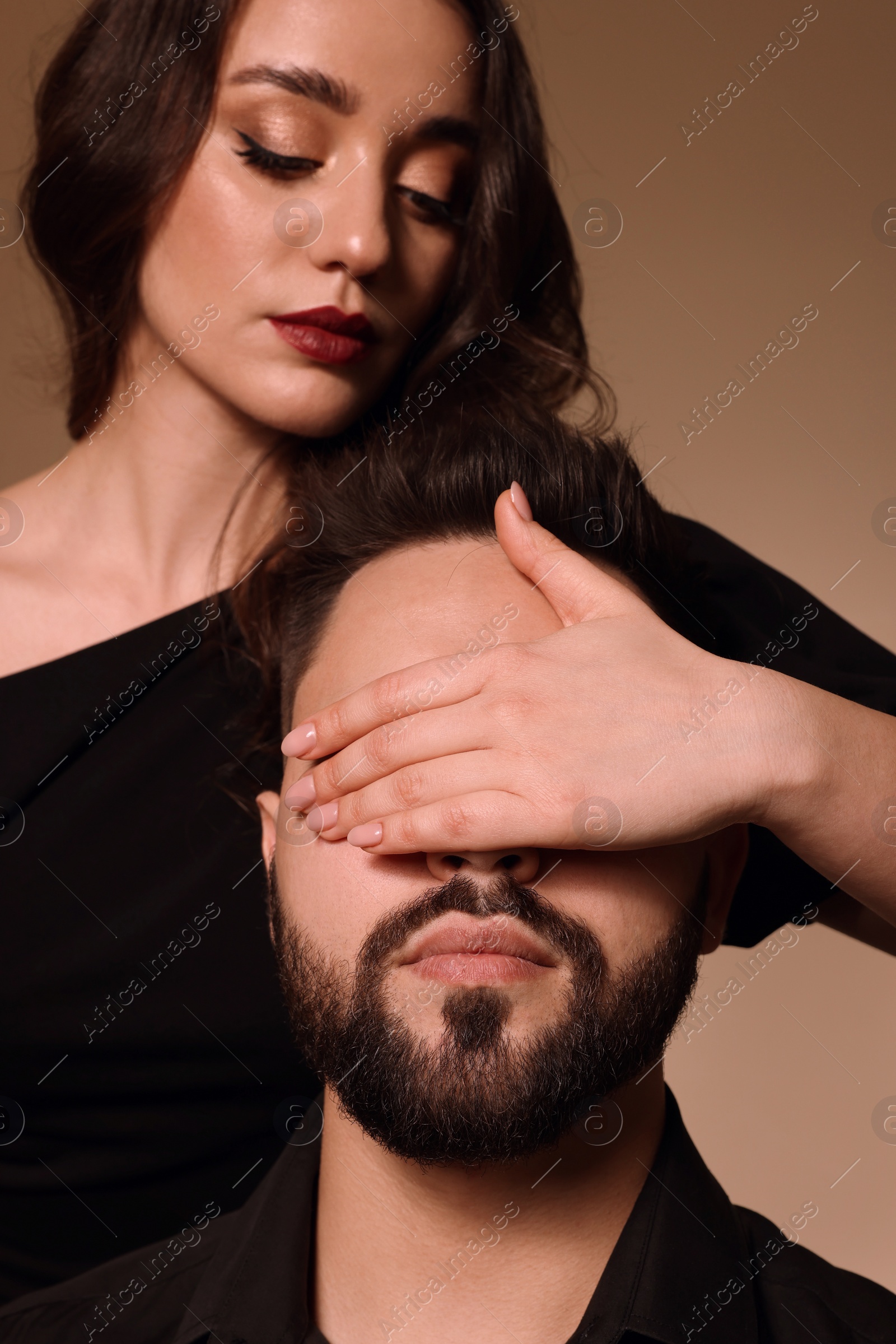 Photo of Bearded man with sexy lady on light brown background