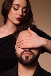 Photo of Bearded man with sexy lady on light brown background