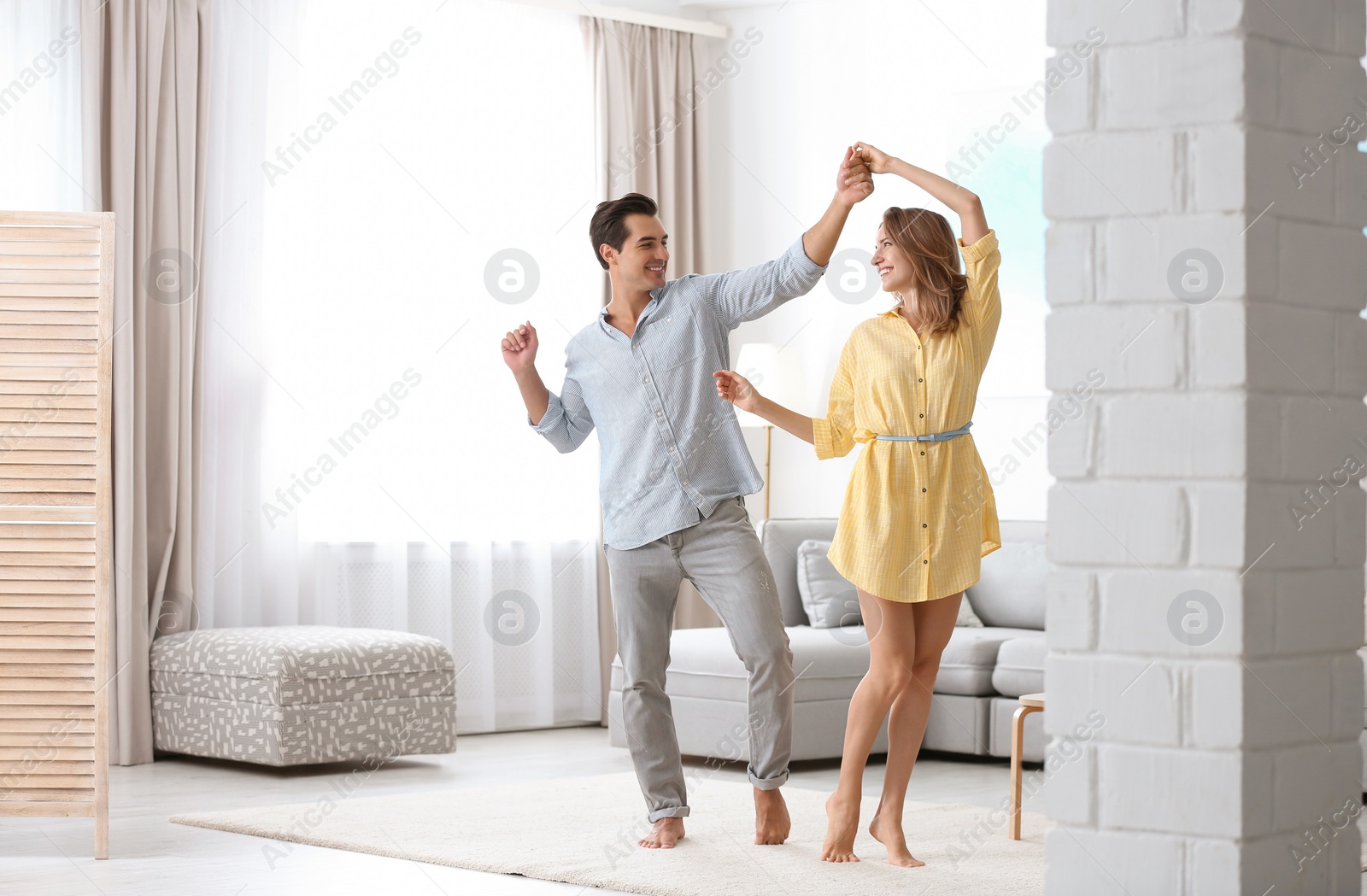 Photo of Beautiful young couple dancing in living at home