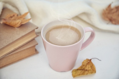 Cup of delicious hot drink on white table