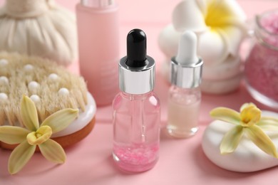 Photo of Composition with spa cosmetic and flowers on pink wooden table, closeup