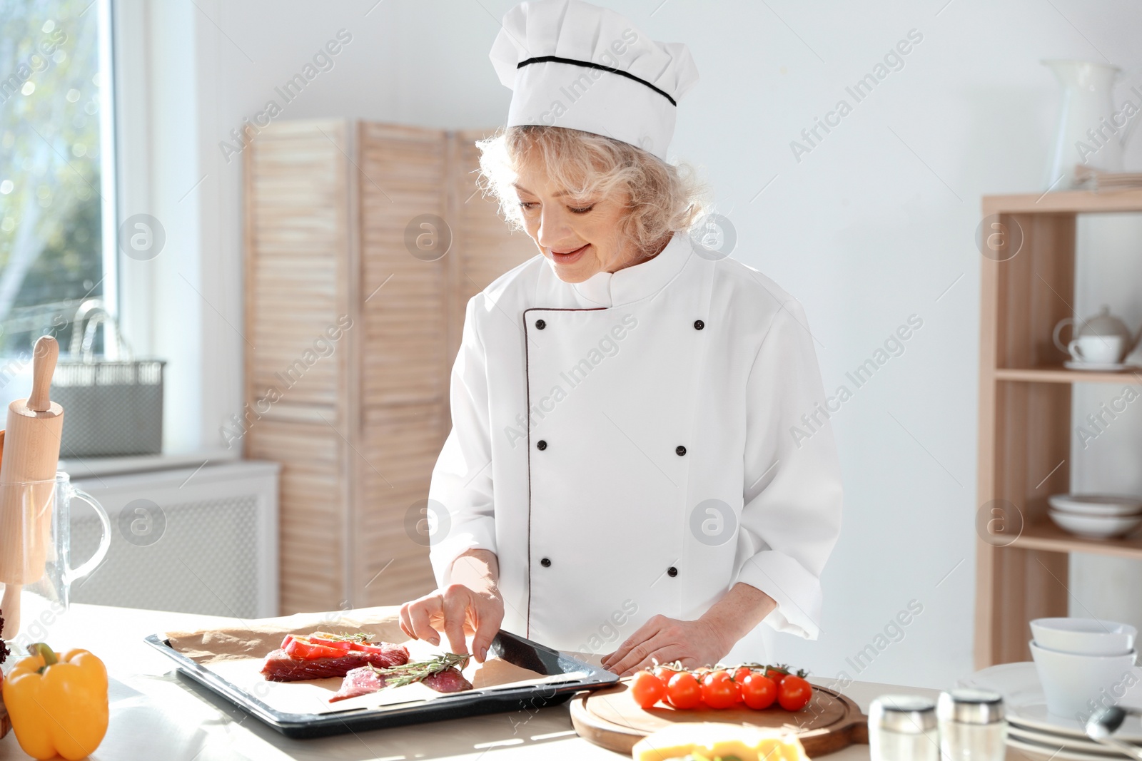 Photo of Professional female chef preparing meat in kitchen