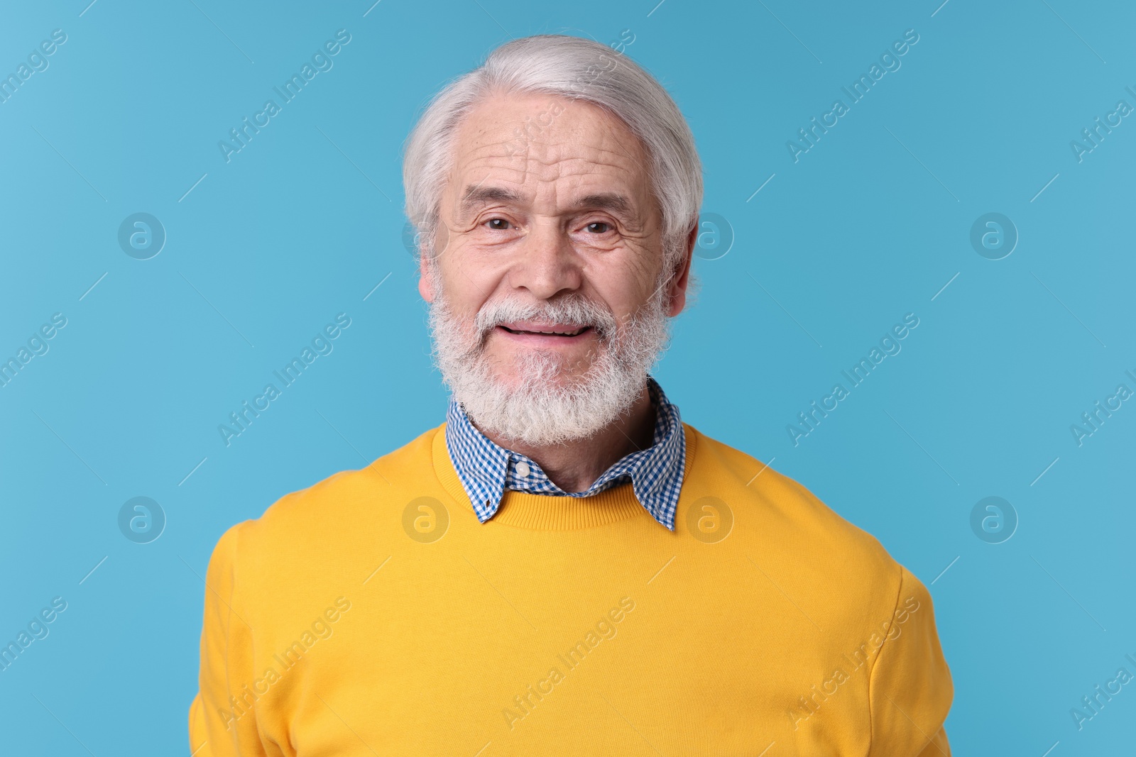 Photo of Portrait of stylish grandpa on light blue background