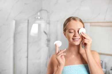 Photo of Beautiful young woman with cotton pads indoors