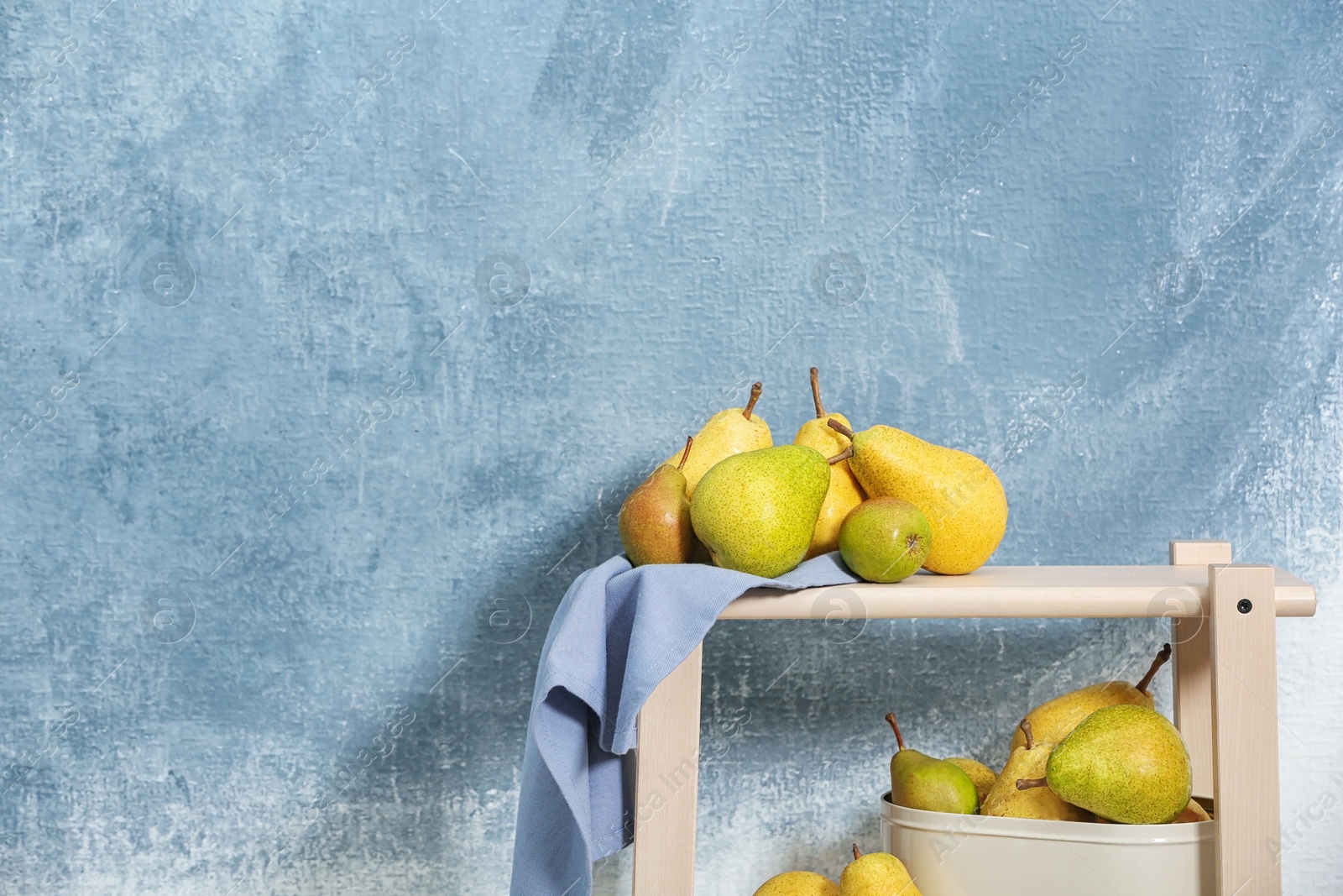 Photo of Fresh ripe pears on table against color background. Space for text