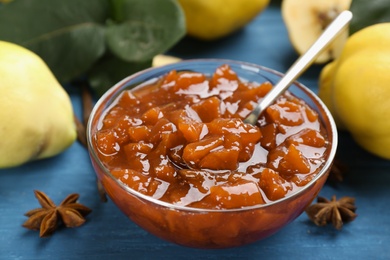 Delicious quince jam on blue wooden table, closeup