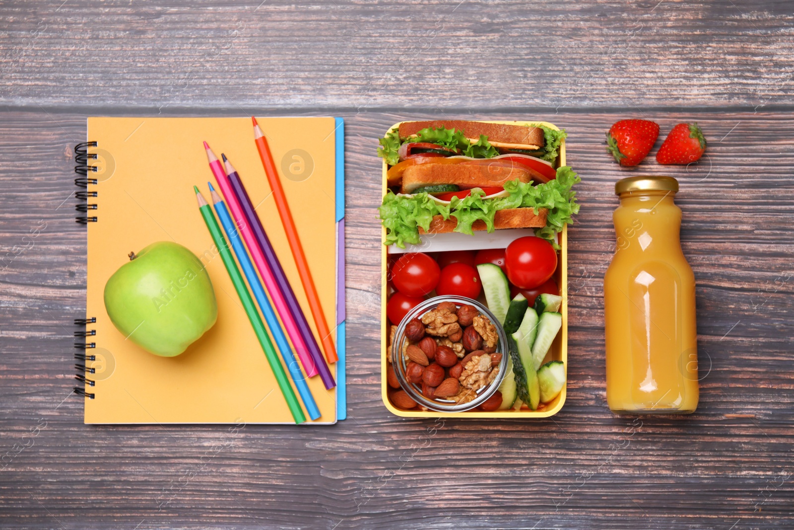 Photo of Lunch box with healthy food for schoolchild and different stationery on wooden table, flat lay