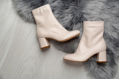 Pair of stylish leather shoes on faux fur, flat lay