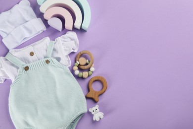 Photo of Flat lay composition with baby clothes and accessories on violet background, space for text