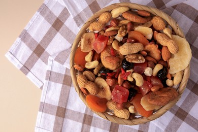 Mixed dried fruits and nuts on beige background, top view. Space for text