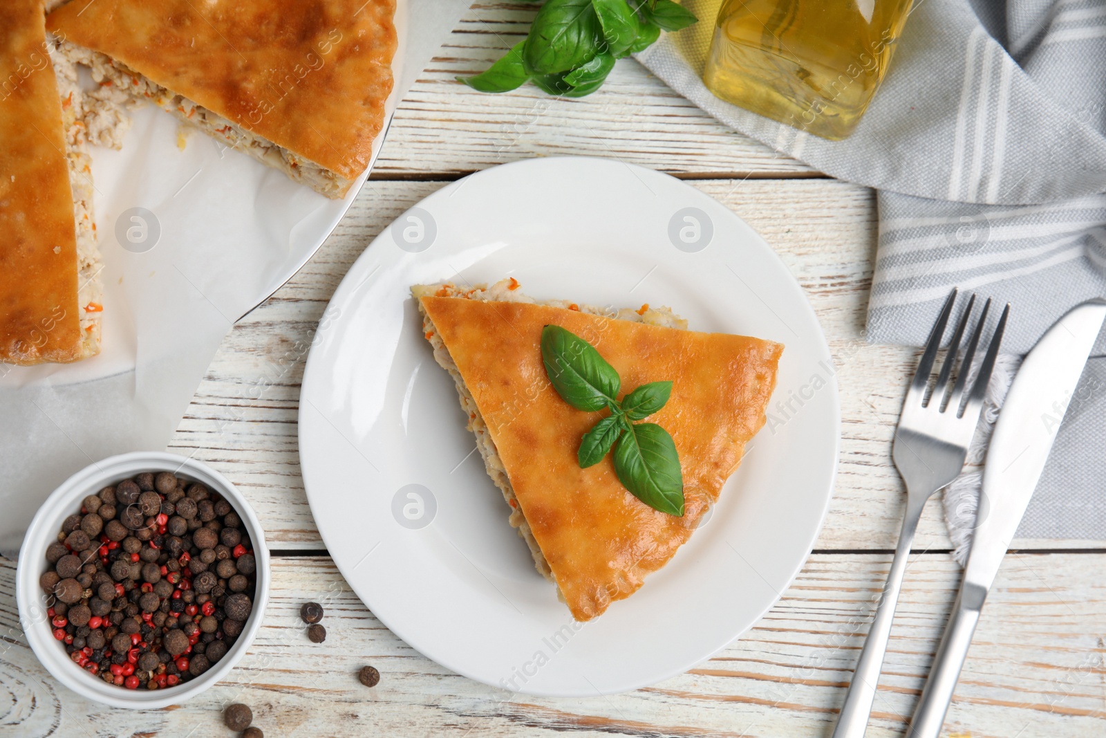 Photo of Delicious meat pie served on white wooden table, flat lay