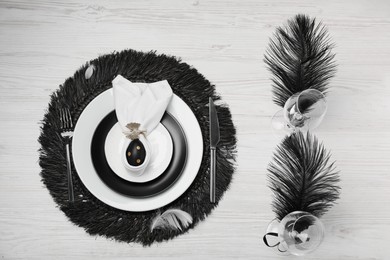 Festive table setting with bunny ears made of black egg and napkin, flat lay. Easter celebration