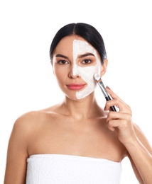 Photo of Young woman applying cleansing mask on face against white background