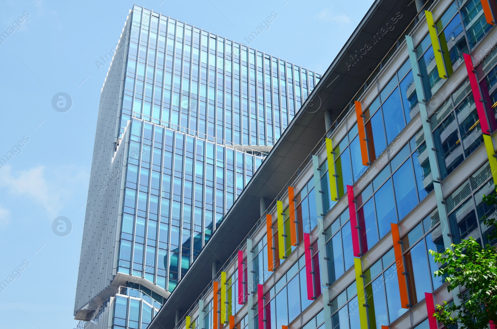 Photo of Exterior of beautiful modern skyscraper against blue sky, low angle view