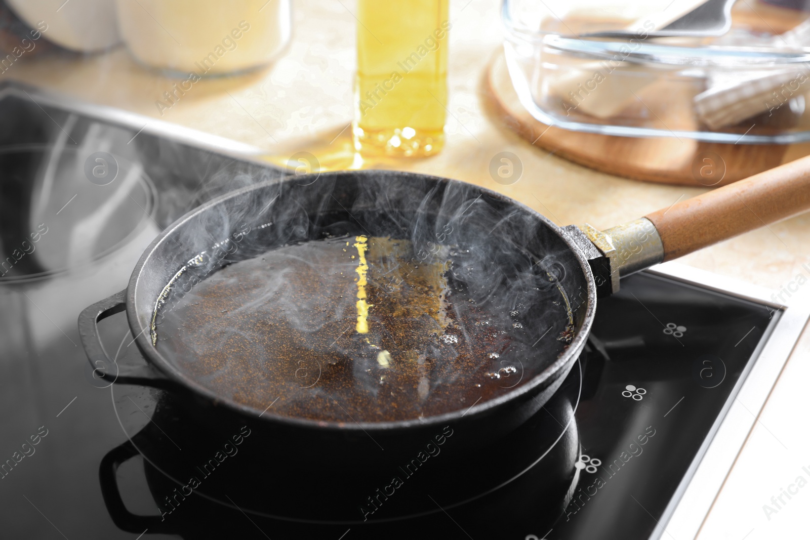 Photo of Frying pan with hot used cooking oil on stove