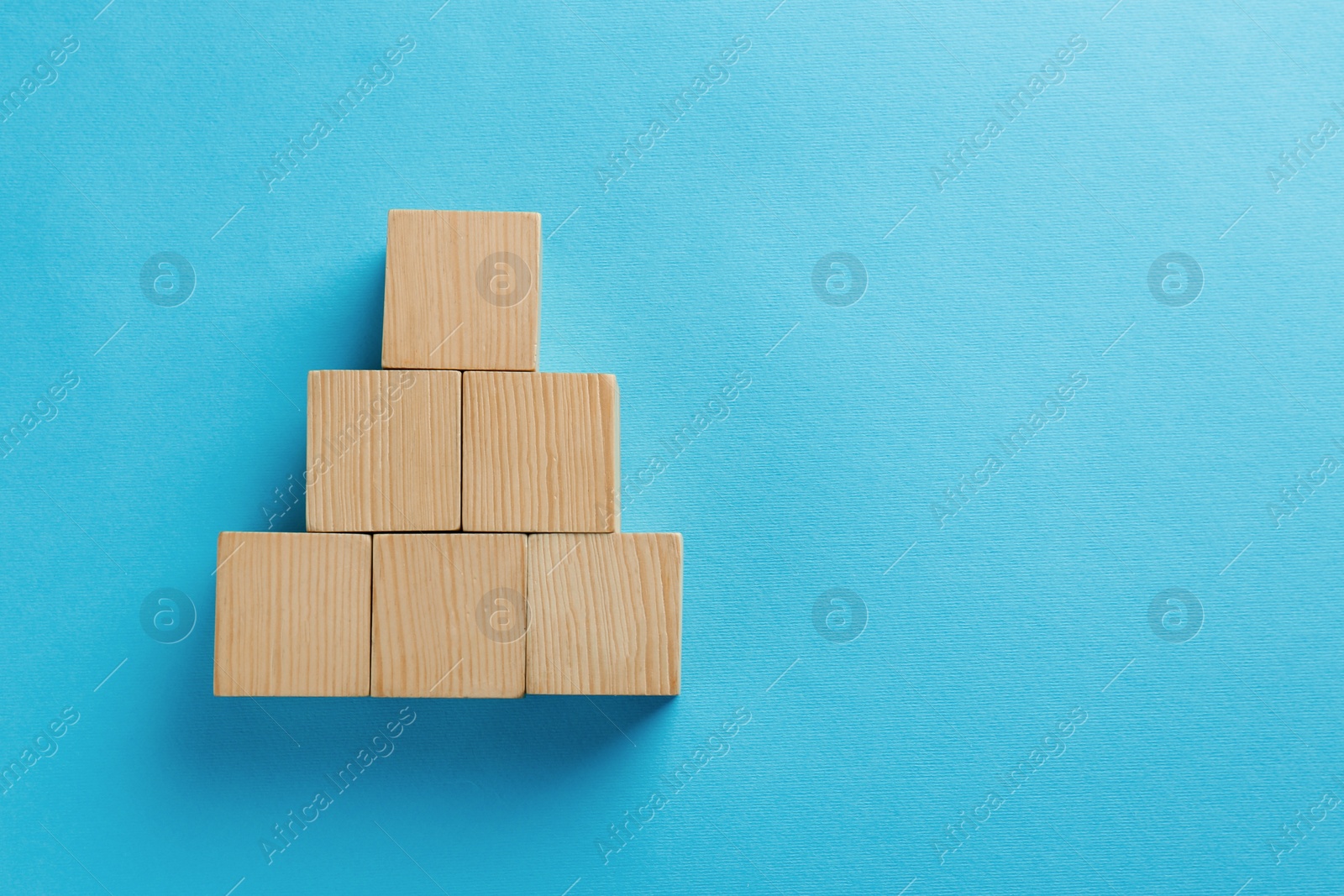 Photo of Blank wooden cubes on light blue background, flat lay. Space for text