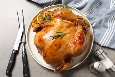 Photo of Tasty roasted chicken with rosemary and lemon served on light grey table, flat lay