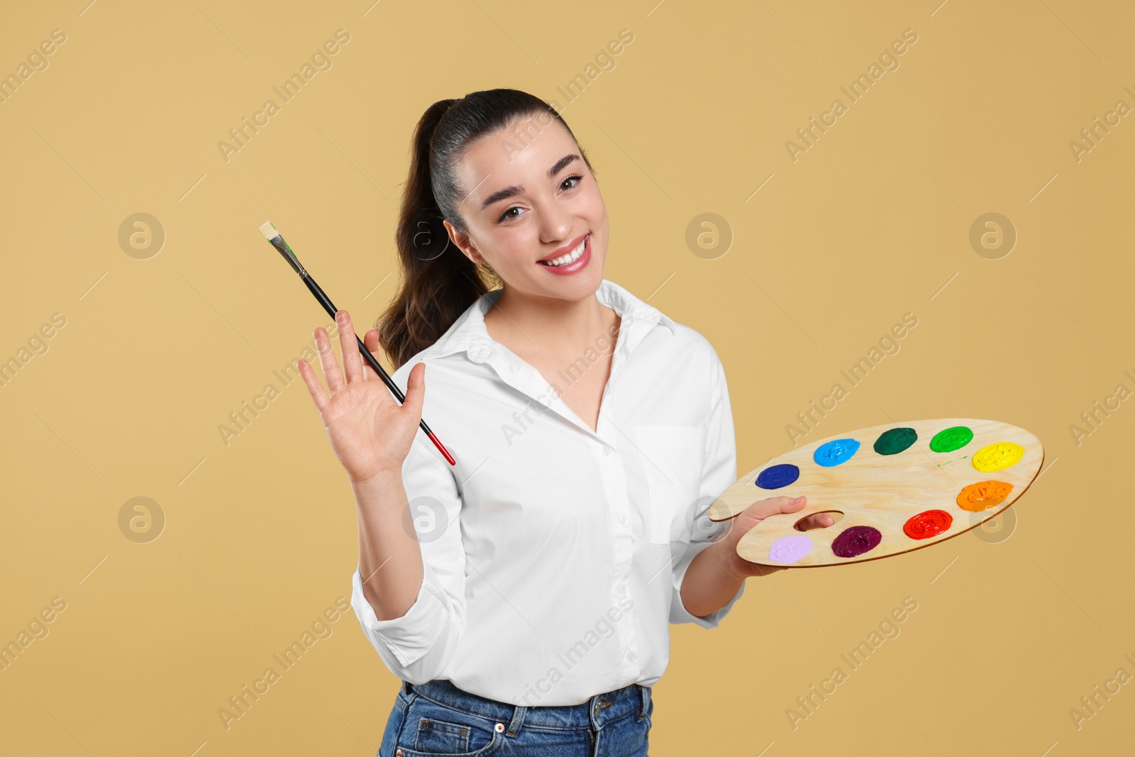 Photo of Woman with painting tools on beige background. Young artist