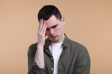 Photo of Portrait of sad man on beige background