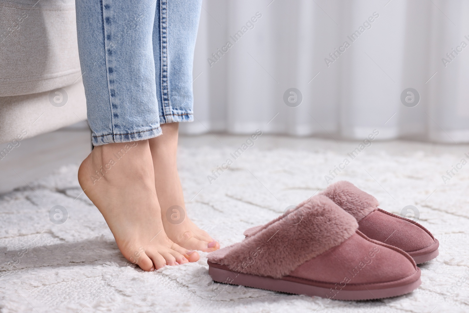 Photo of Woman near soft slippers at home, closeup