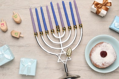 Flat lay composition with Hanukkah menorah and gift boxes on light wooden table