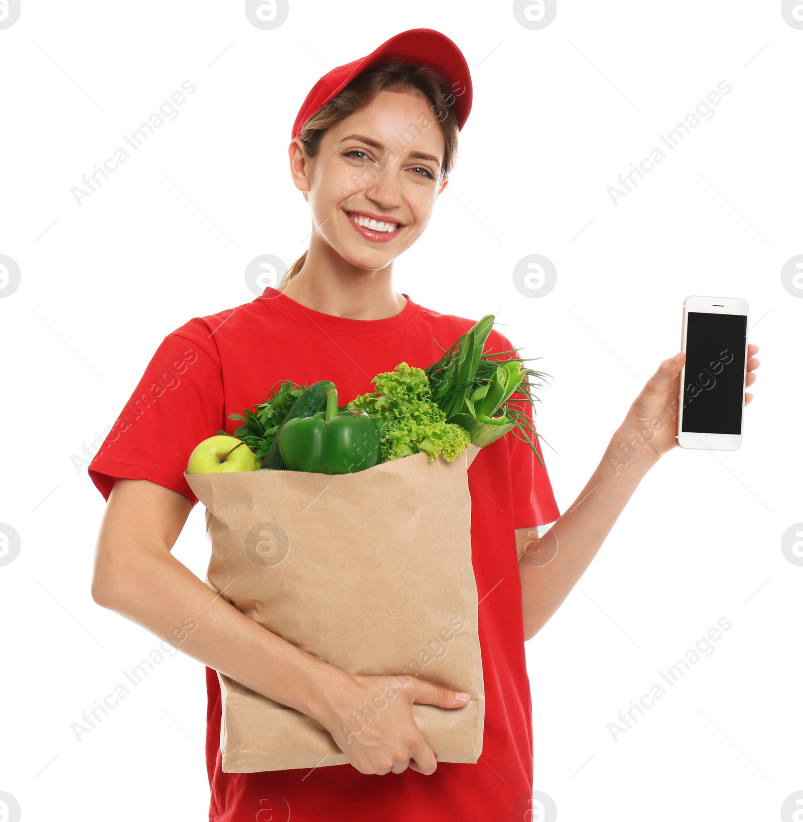 Photo of Delivery woman with bag of fresh vegetables and smartphone on white background, mockup for design