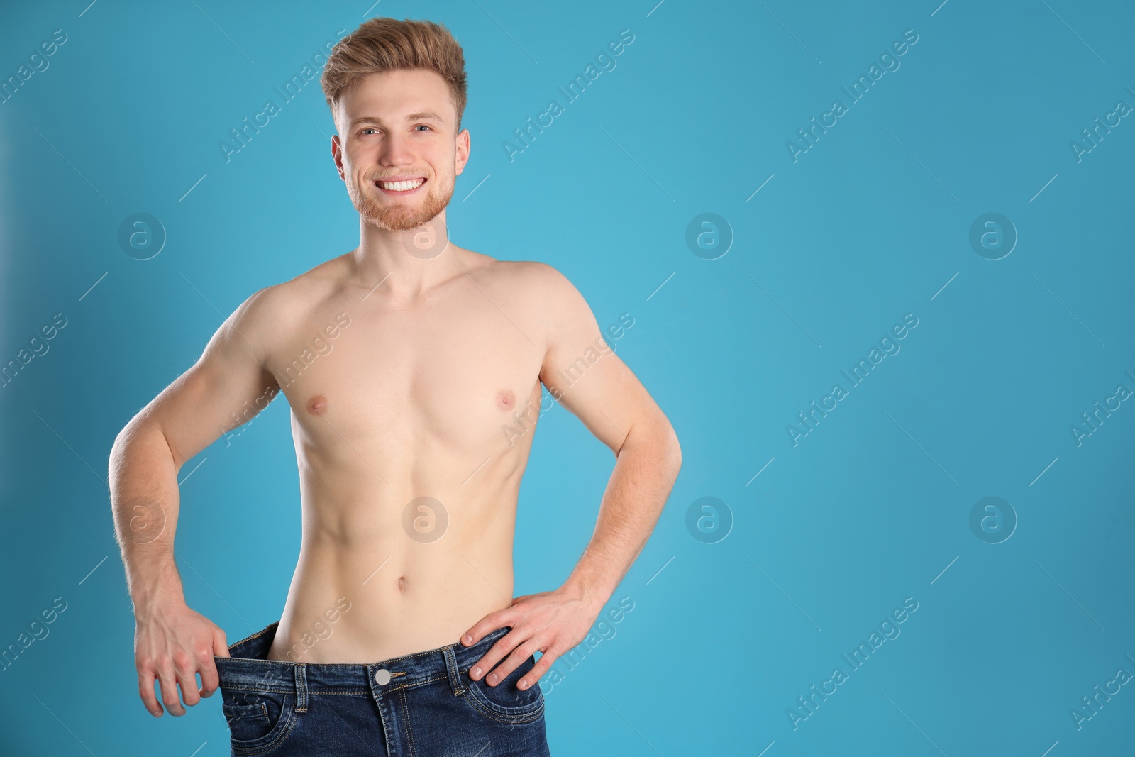 Photo of Handsome man in oversized jeans on color background. Space for text