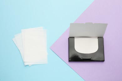 Photo of Package with facial oil blotting tissues on color background, flat lay. Mattifying wipes