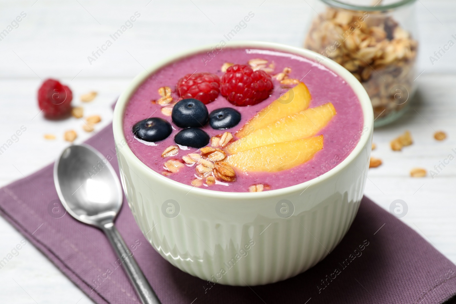 Photo of Delicious acai smoothie with fruits served on white wooden table, closeup