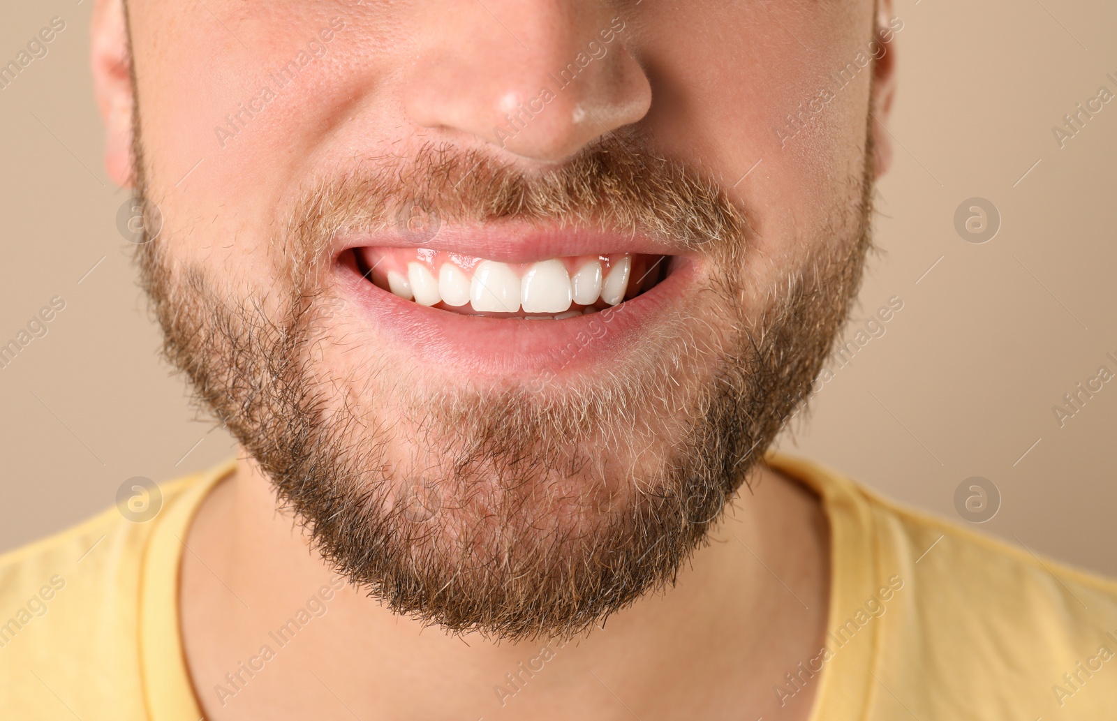 Photo of Young man with healthy teeth on color background, closeup