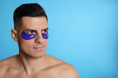 Photo of Man with under eye patches on light blue background. Space for text