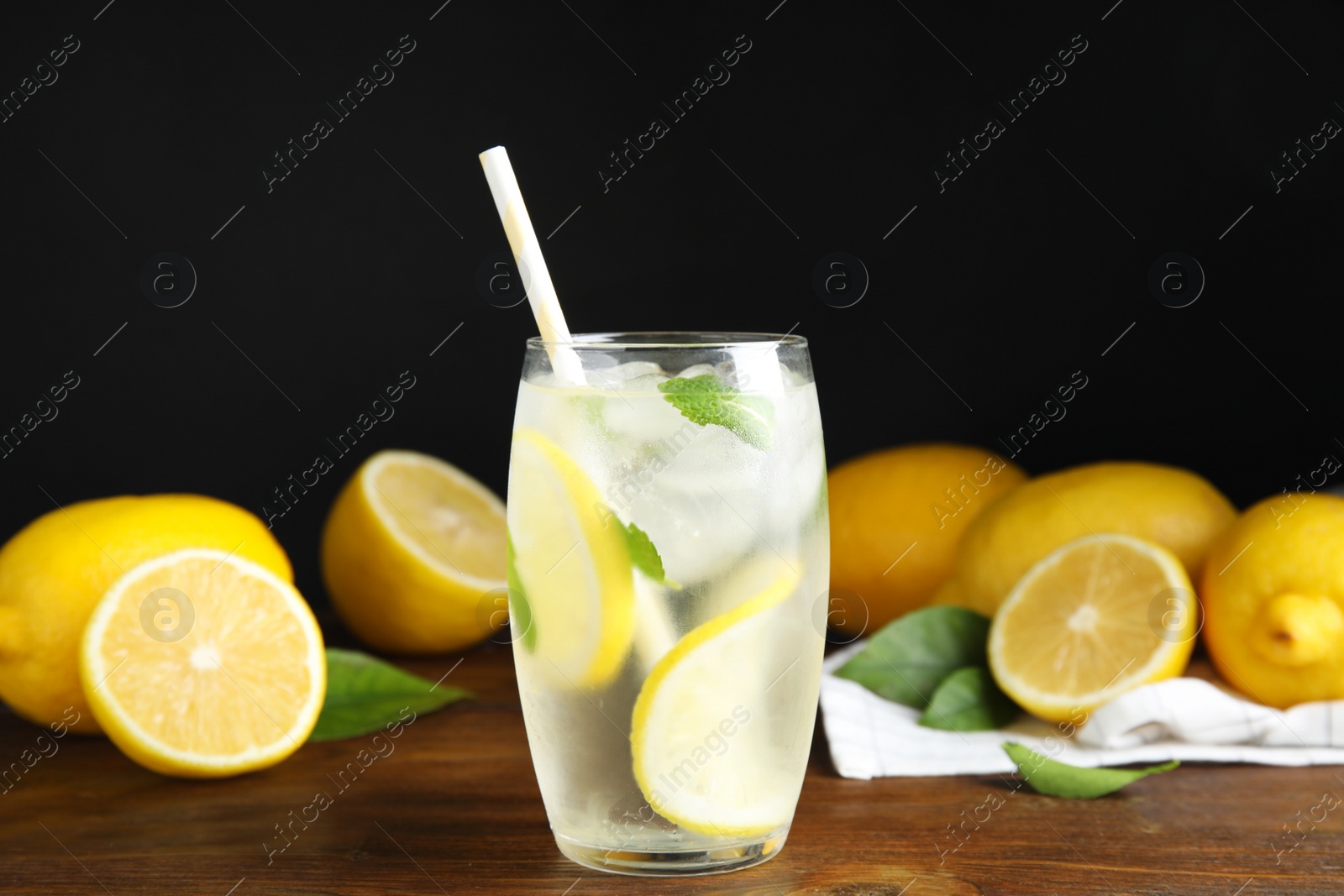 Photo of Cool freshly made lemonade and fruits on wooden table
