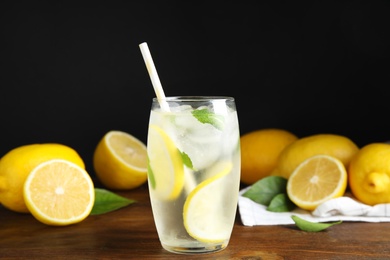 Photo of Cool freshly made lemonade and fruits on wooden table