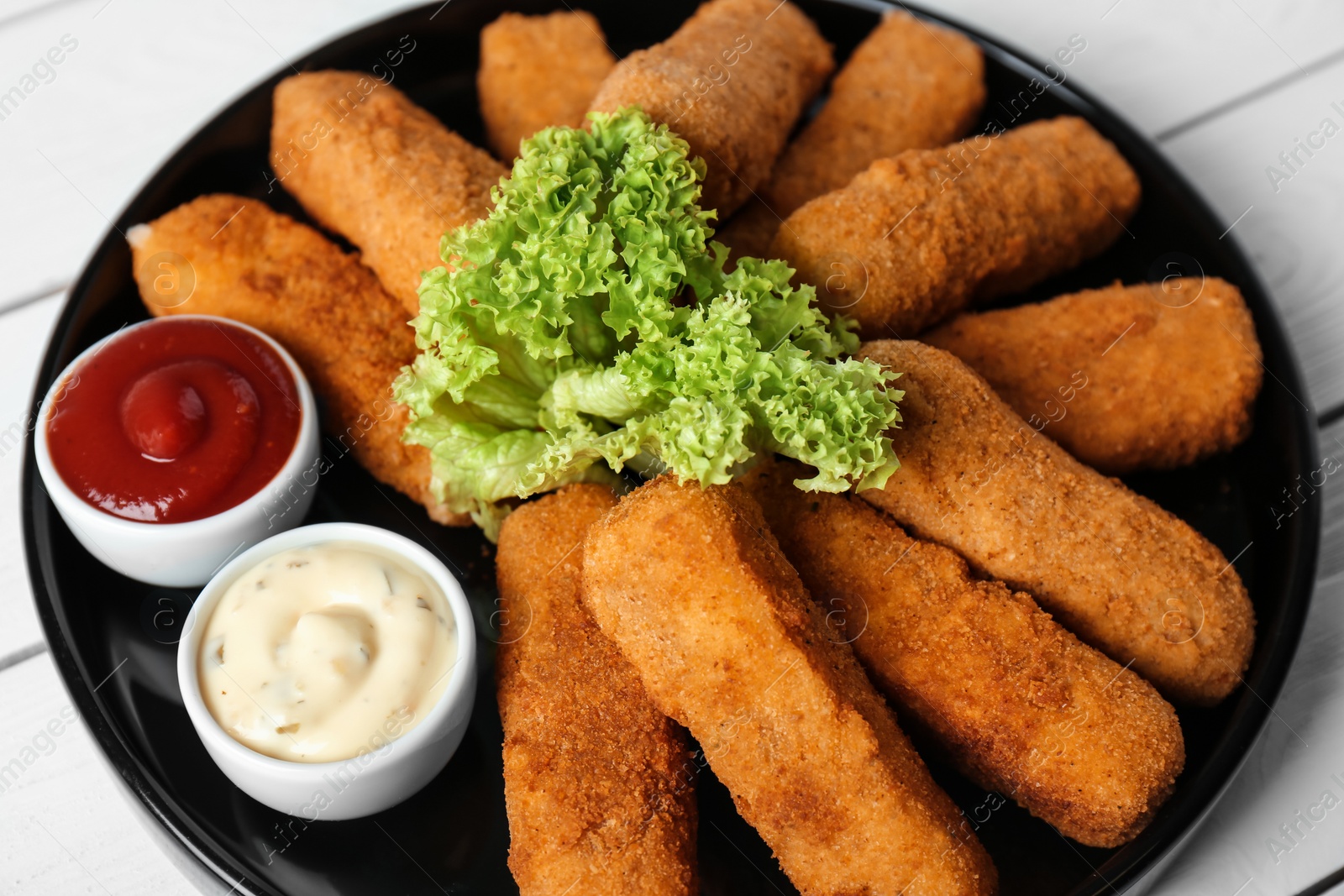 Photo of Plate of cheese sticks and sauces on table, closeup