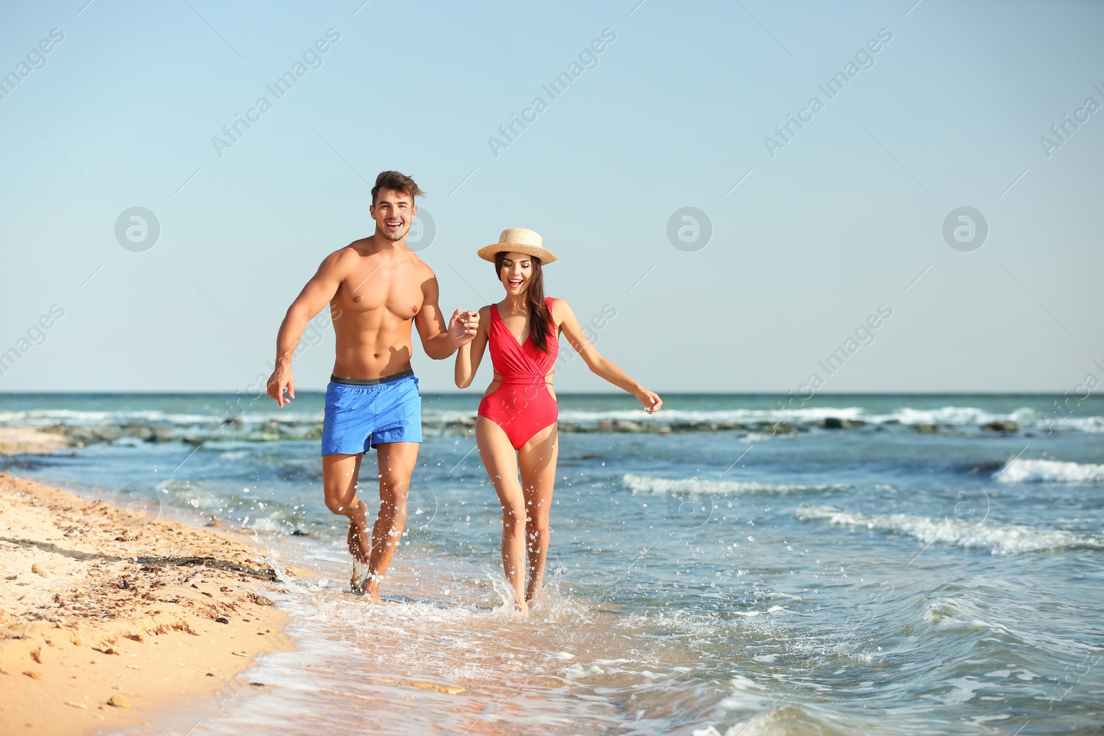 Photo of Happy young couple having fun at beach on sunny day