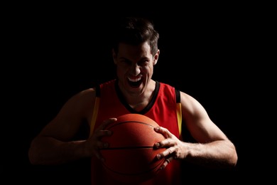 Photo of Basketball player with ball on black background