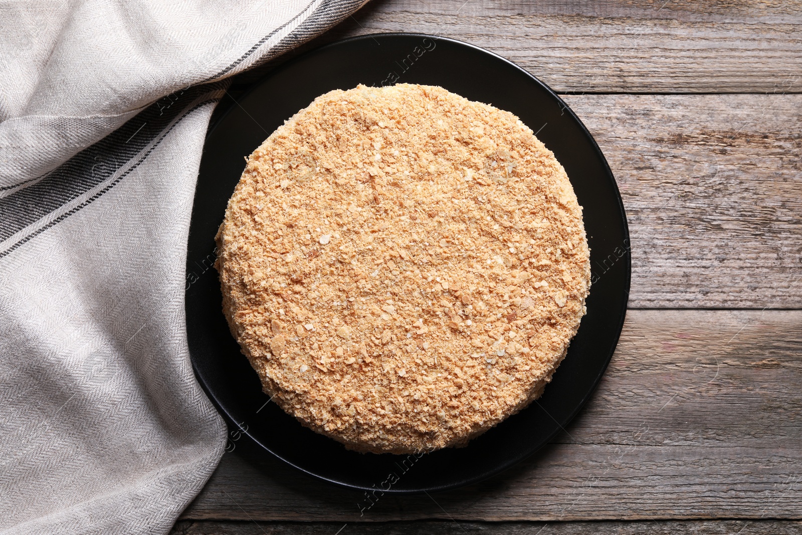 Photo of Delicious Napoleon cake on wooden table, top view