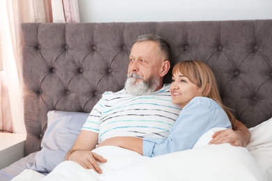 Mature couple together in bed at home