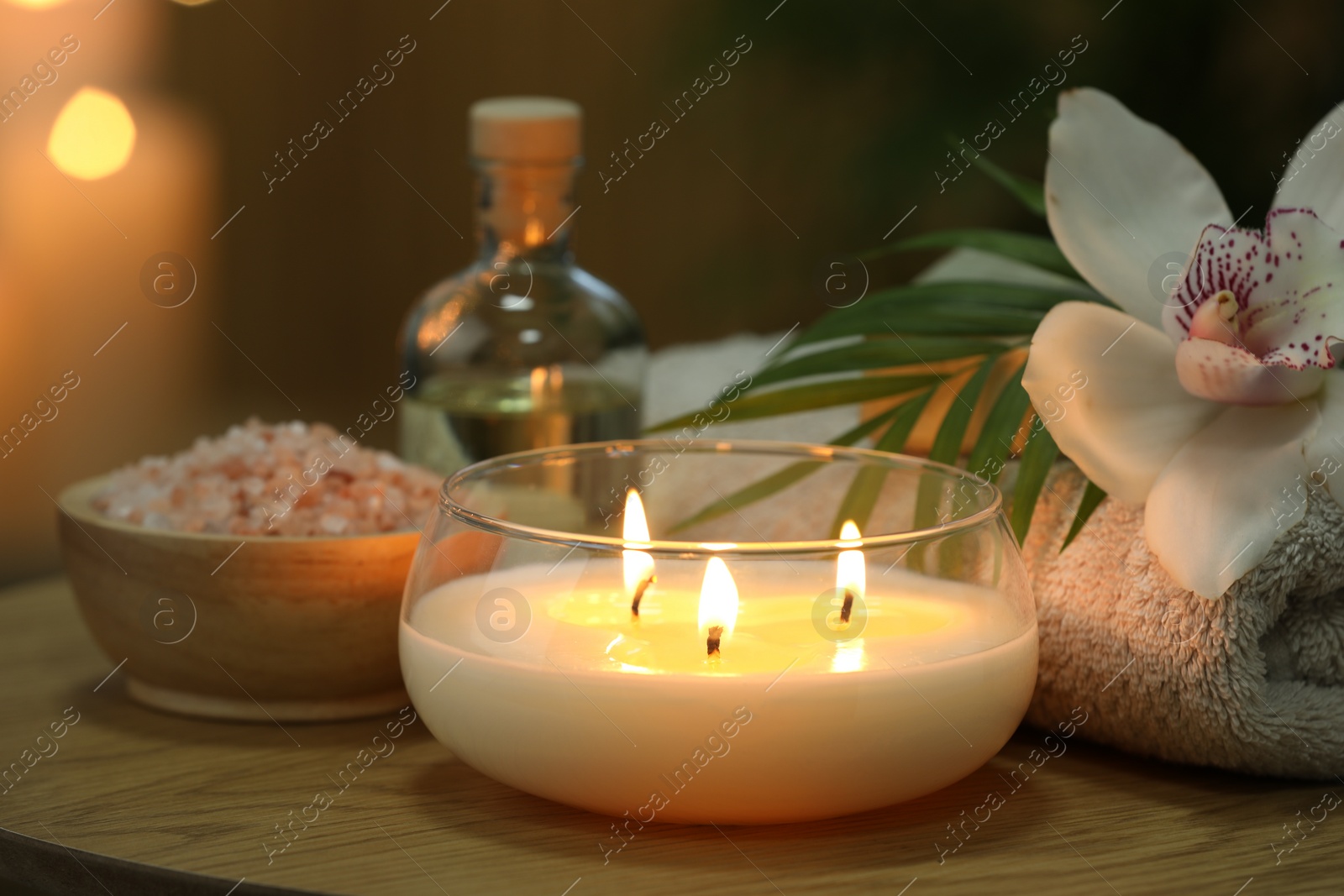 Photo of Beautiful spa composition with burning candle on wooden table, closeup