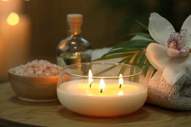 Beautiful spa composition with burning candle on wooden table, closeup