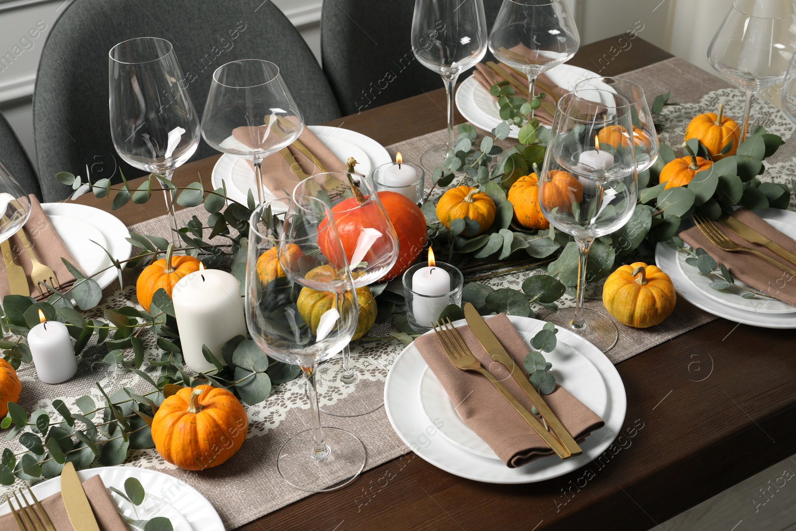 Photo of Beautiful autumn table setting. Plates, cutlery, glasses, pumpkins and floral decor