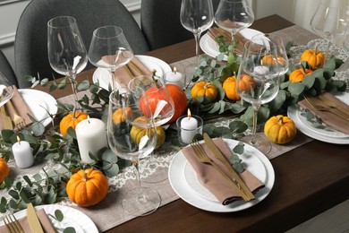 Photo of Beautiful autumn table setting. Plates, cutlery, glasses, pumpkins and floral decor
