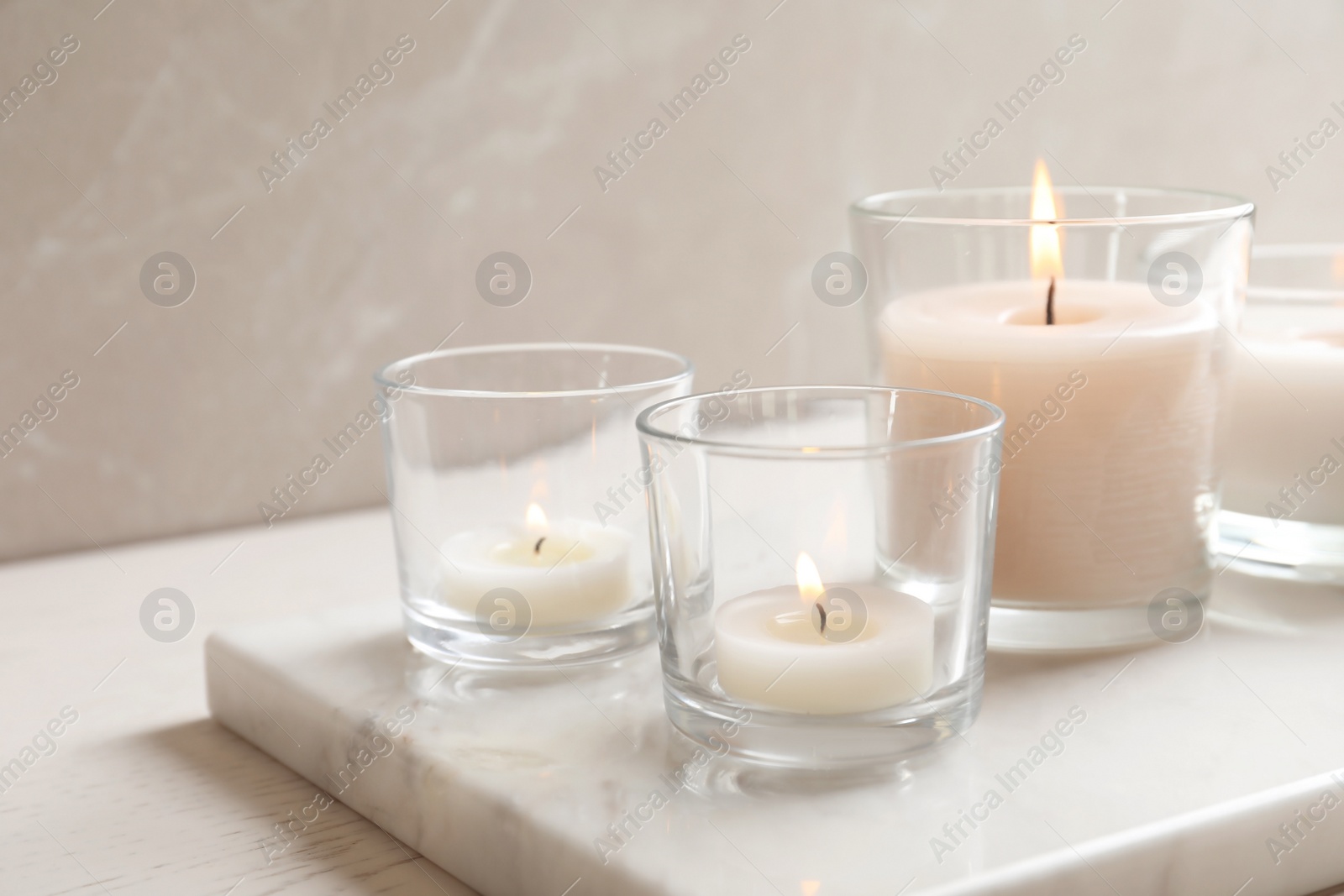 Photo of Burning candles in glasses on marble board