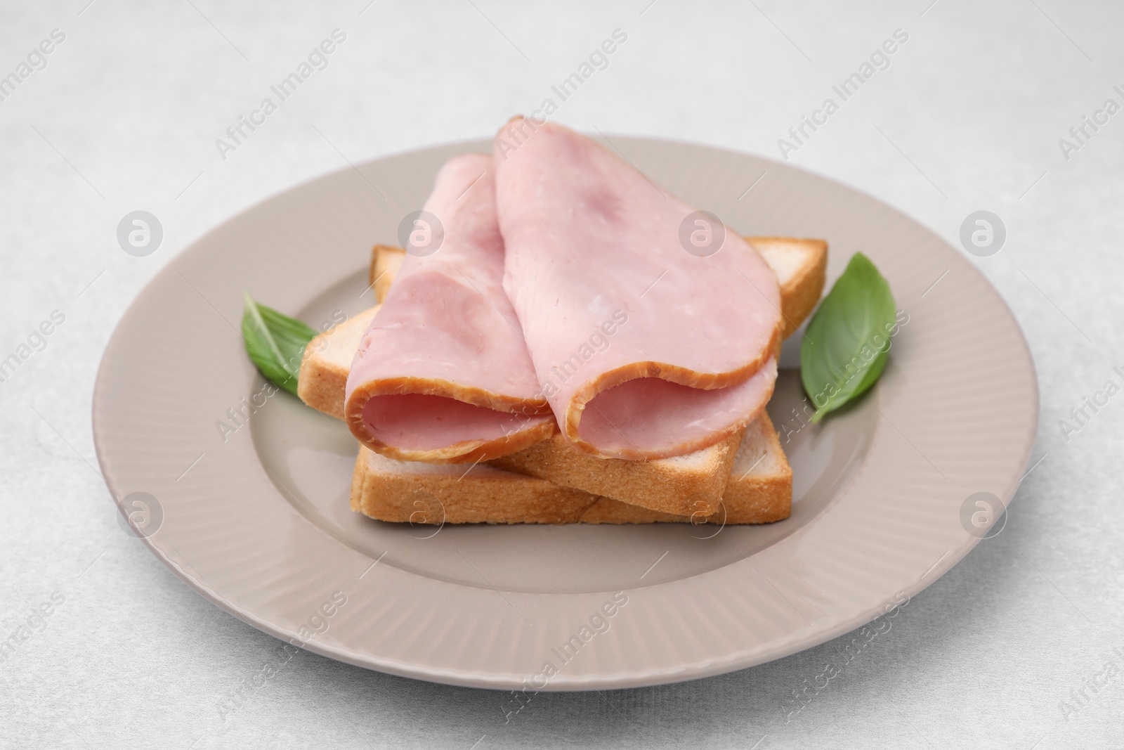 Photo of Delicious sandwich with ham on light table, closeup