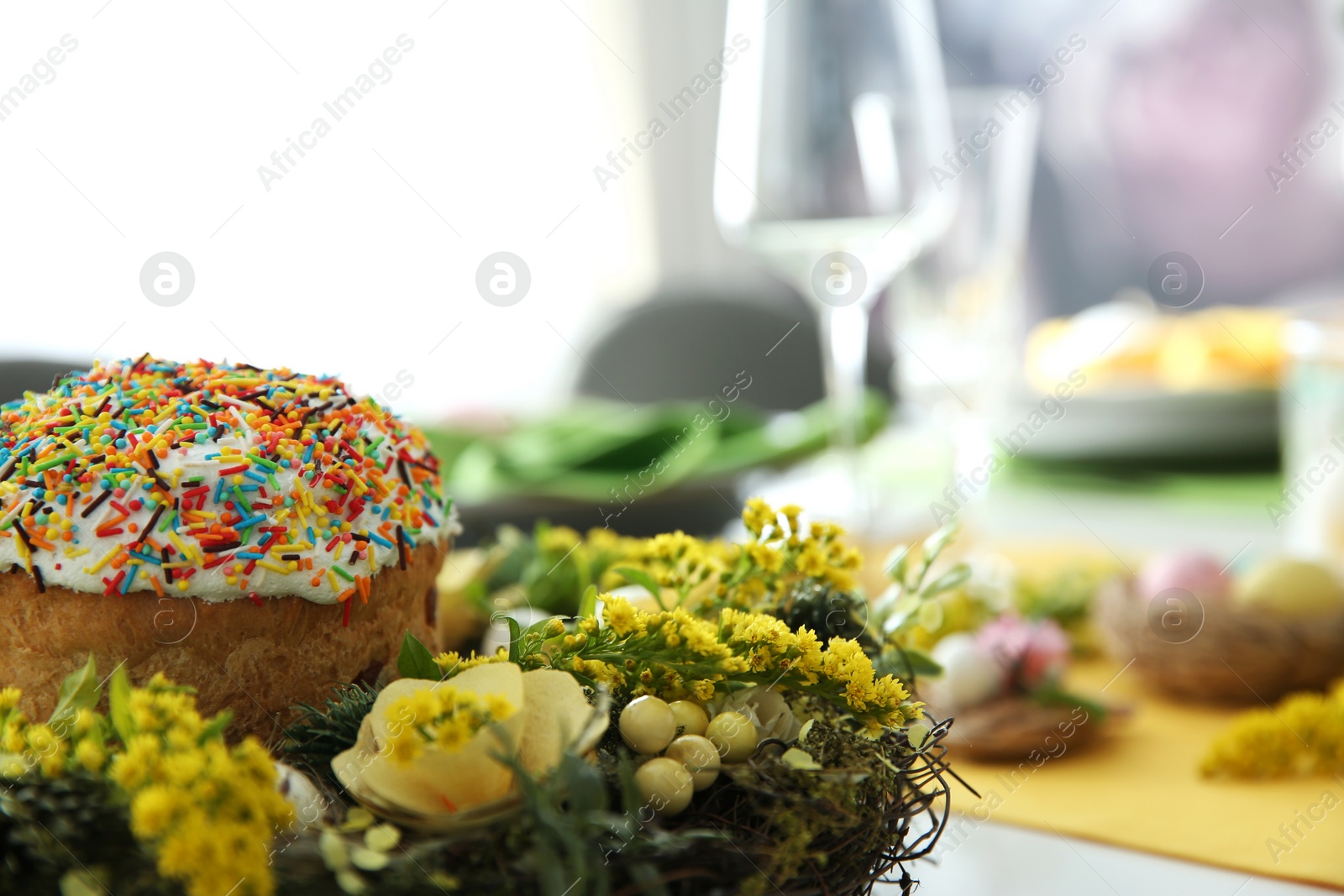 Photo of Beautiful wreath with Easter bread, closeup. Festive table setting